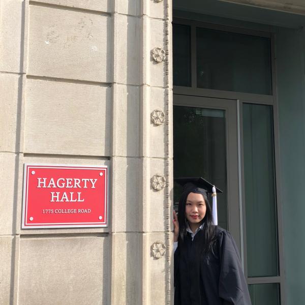 Kiki Hou next to Hagerty Hall during graduation