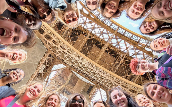 students in a circle under the Eiffel Tower