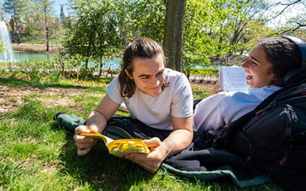 two students sitting on the grass