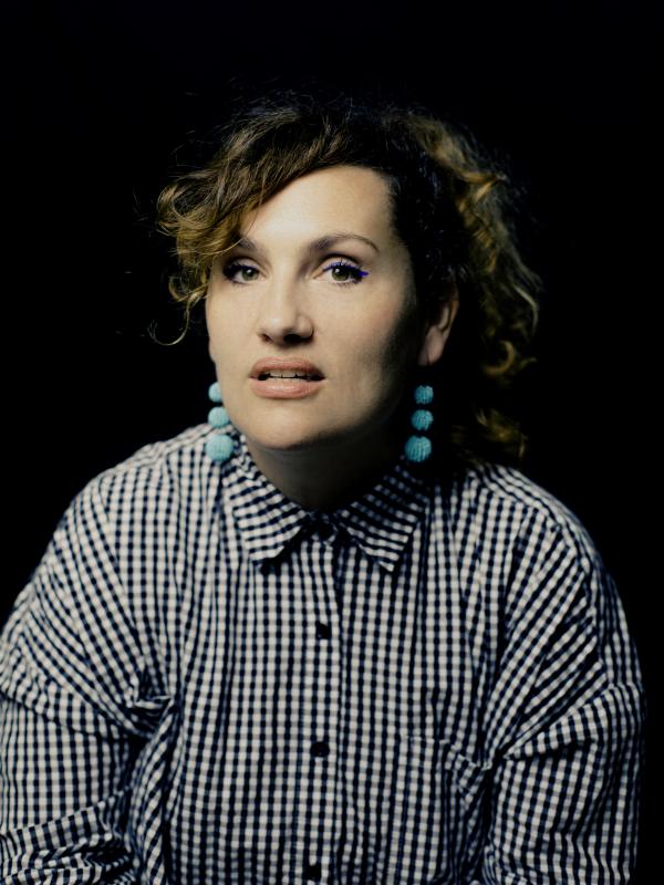 Headshot of Lucille Toth wearing blue earrings