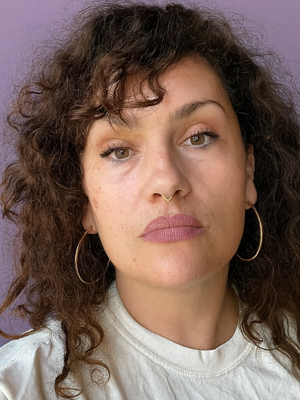 Dr Toth wears a nose ring and earring. She has curly brown hair.